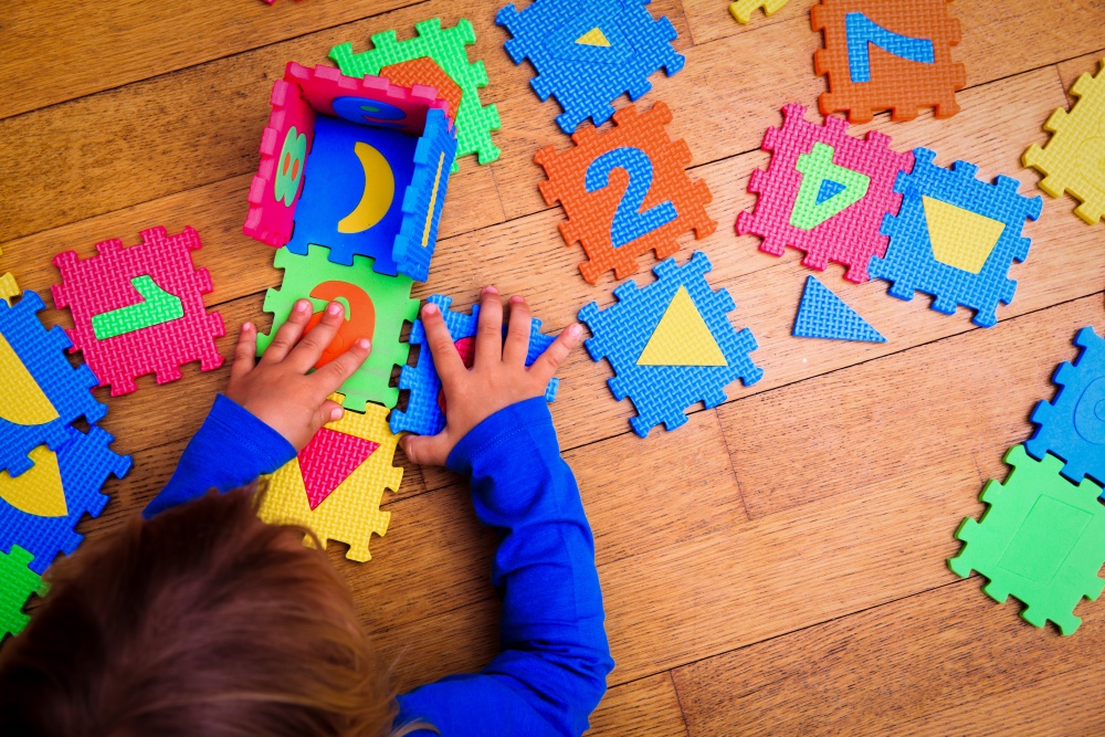 Kind mit Puzzle (iStock)
